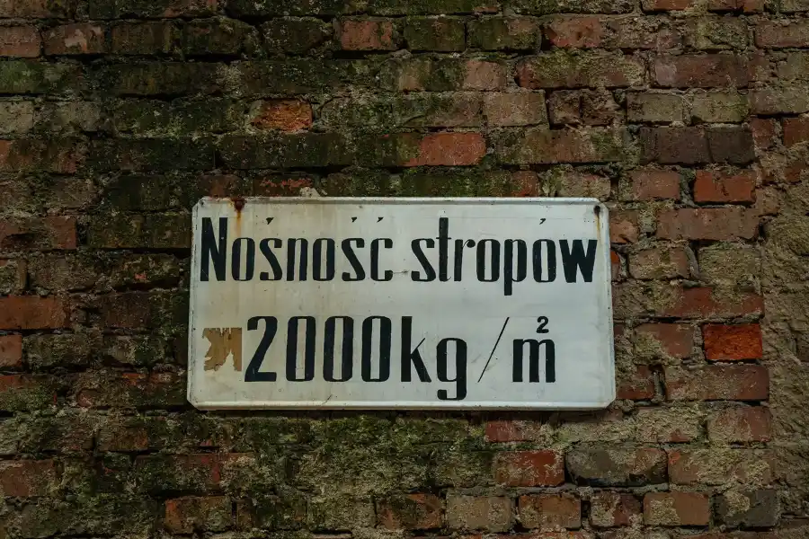 Ceglany mur z pozosta o ciami instalacji w industrialnej przestrzeni elektrociep owni