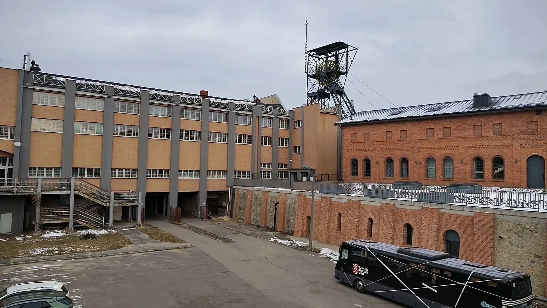 Panorama kompleksu Sztolnia Królowa Luiza w Zabrzu Widok na dziedziniec kompleksu kopalni Królowa Luiza w Zabrzu z budynkami, wieżą szybową i autokarem